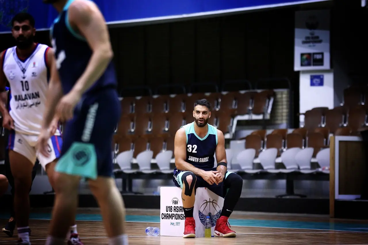 Siddende basketballspiller på banen